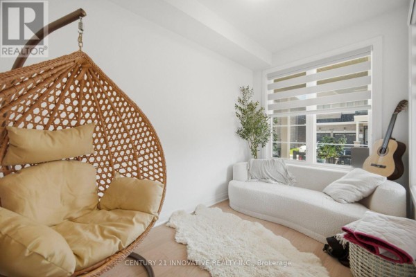 Bright room with a wicker hanging chair, a white sofa, a window with blinds, and a guitar. - 1282 Stirling Todd Terrace, Milton