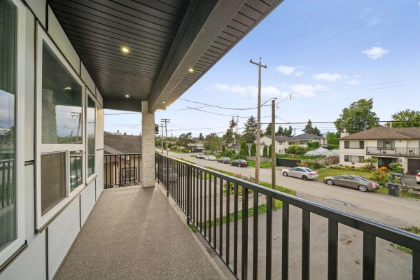 View from the front porch overlooking a suburban street with cars and houses. - 12822 114a Avenue, Surrey