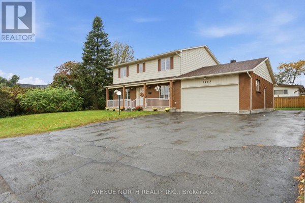 Three-quarter view of the front and side of a two-story house with a long driveway. - 1283 Surrey Avenue, Ottawa
