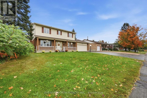 View from the lawn of a two-story house with a covered porch and brick accents. - 1283 Surrey Avenue, Ottawa