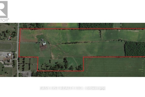 Aerial view of a large farm property bordered by red lines, showing fields and wooded areas. - 12860 County  Road 43, North Dundas