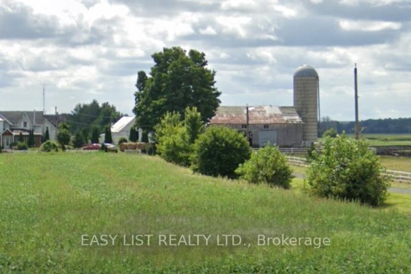 Farm buildings including a barn and silo, surrounded by green fields and trees. - 12860 County  Road 43, North Dundas
