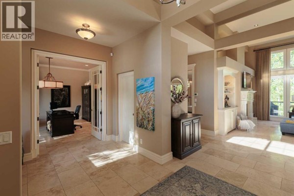 Hallway with beige walls, tiled floors, French doors leading to an office, and access to a living area. - 129 Heritage Lake Drive, Heritage Pointe