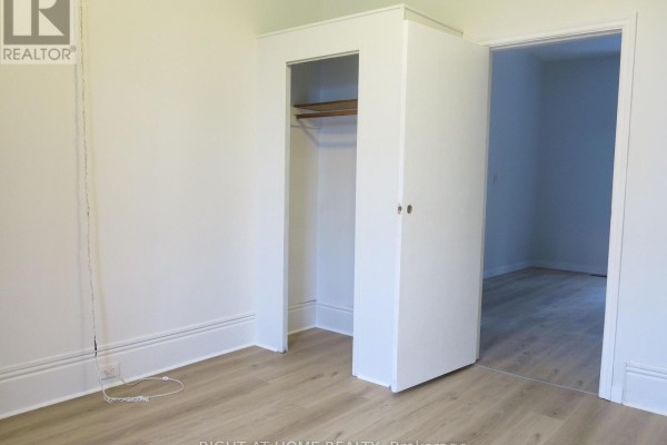 Interior view of a room with light wood laminate flooring and an open closet space. - 129 Walnut Street, London North