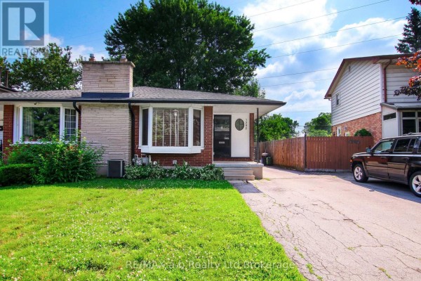 Exterior view of the house from the driveway, showing the front entrance and lawn. - 1292 Sorrel Road, London East