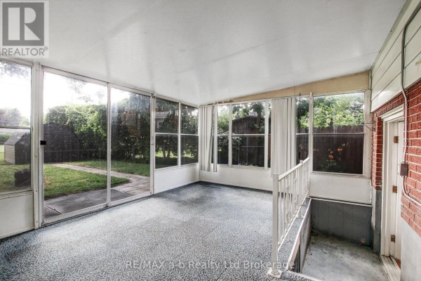 Interior of a screened-in porch with carpeted floor and large windows overlooking the yard. - 1292 Sorrel Road, London East