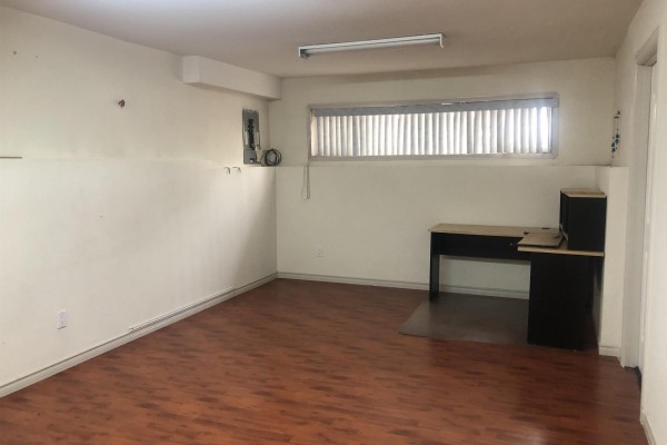 Large room with white walls, wood floor, a desk, and a window with blinds. - 12930 109 Avenue, Surrey
