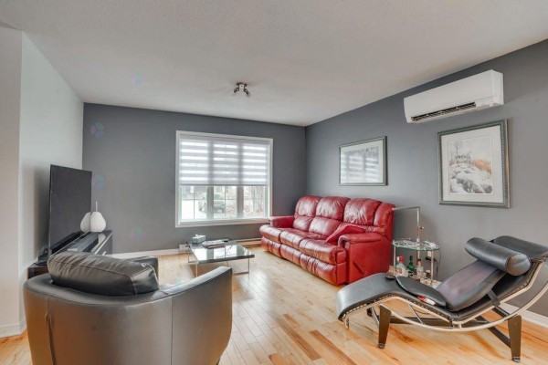 Living room with grey walls, red sofa, chaise lounge, air conditioning unit, and window blinds. - 1294 Rue D'alma, Gatineau