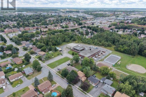 Aerial view of suburban homes, school, sports field, and pool - Sudbury