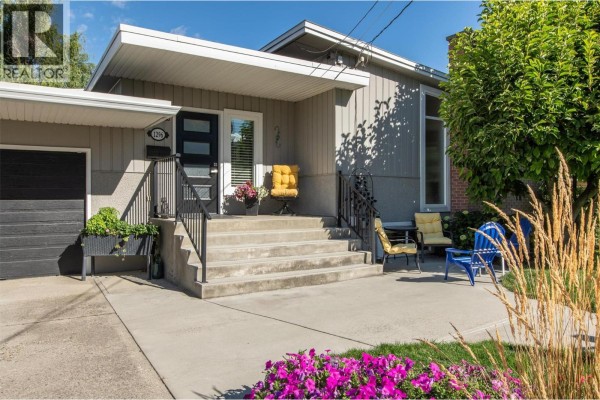 Front exterior of the duplex with a garage and driveway. - 1296 Kelglen Crescent, Kelowna