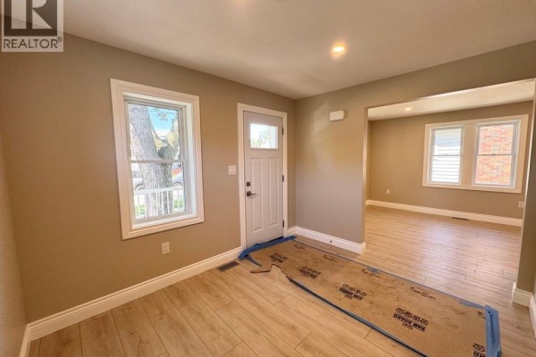 View from inside looking towards the front door and a window with a tree outside. - 1296 Laurendeau Avenue, Windsor