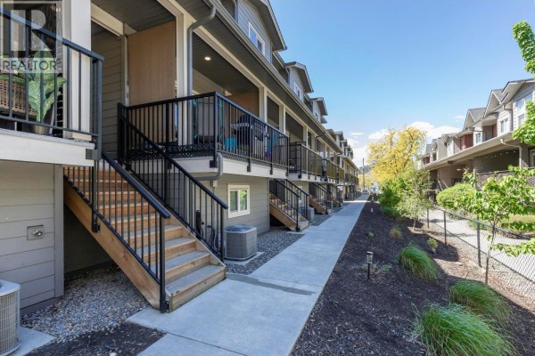 View of neighboring units and trees, snow-covered ground, and fenced yard area. - 1297 Findlay Road Unit# 9, Kelowna