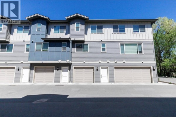 Backyard view with snow-covered pathway, fenced area, and air conditioning unit. - 1297 Findlay Road Unit# 9, Kelowna