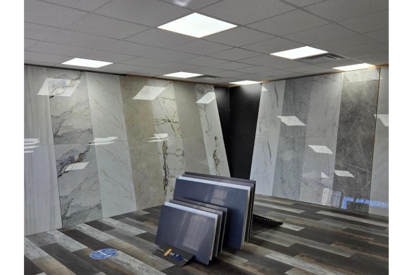 Interior showroom displaying large format tiles with various patterns on walls and floor. - 12975-12977 80 Avenue, Surrey