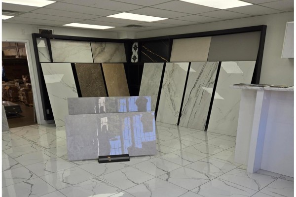Corner of showroom with wall displays of tiles and a display of grey polished tiles. - 12975-12977 80 Avenue, Surrey