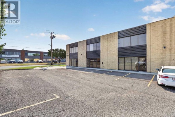 View of the side of a commercial building with a parking lot and neighboring businesses. - 13, 4063 74 Avenue Se, Calgary