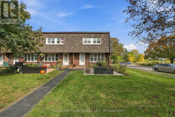 Exterior view of a brick townhouse with attached garages on the right. - 13 - 162 Cromwell Street, Trent Hills