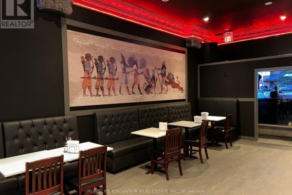 View of the restaurant's dining area with black booths, tables, and a red illuminated ceiling. - 13 - 200 Marycroft Avenue E, Vaughan
