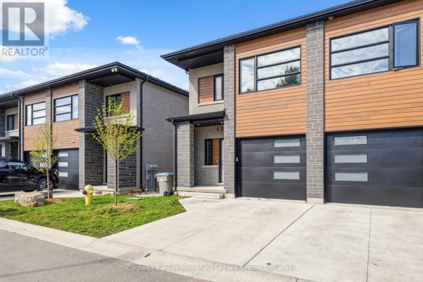 Side view of a townhouse complex showing multiple units with contemporary architecture and landscaping. - 13 - 275 James Street S, St  Marys