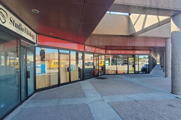 Exterior view of storefronts, including Marche Istanbul, with large glass windows and covered walkways. - 13 - 3220 Dufferin Street, Toronto
