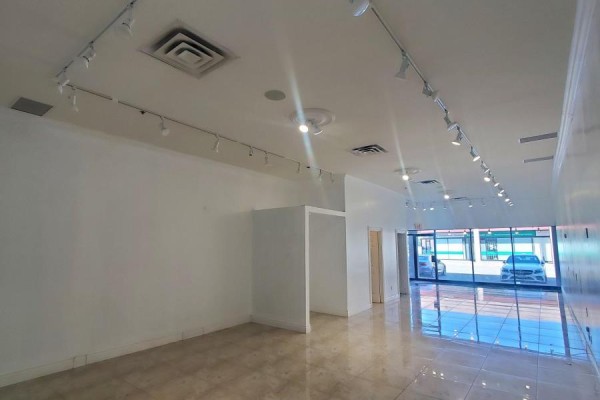 Interior of an empty commercial space with white walls, tile flooring, and track lighting. - 13 - 3220 Dufferin Street, Toronto