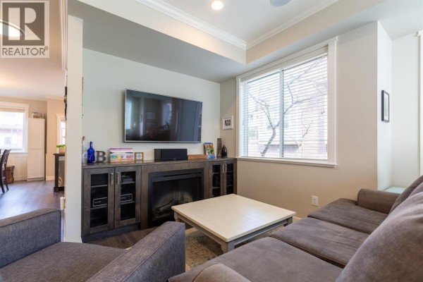 Bedroom with light green walls, a double bed, desk, and a window. - 13 10480 248 Street, Maple Ridge