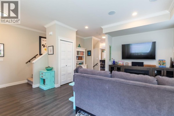 Outdoor patio area with a table, chairs, barbecue, and views of townhouses. - 13 10480 248 Street, Maple Ridge