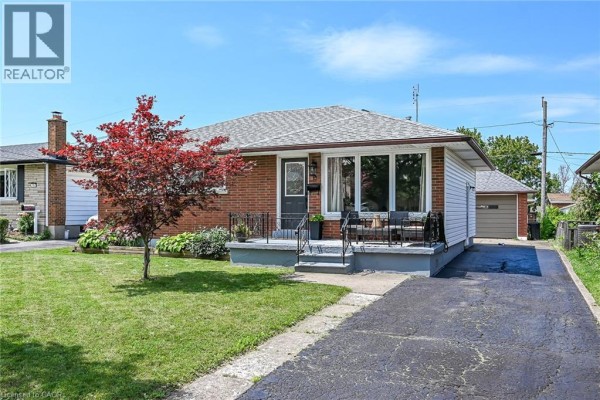 Side view of the brick bungalow with a driveway leading to the detached garage. - 13 Allanburg Road S, St  Catharines
