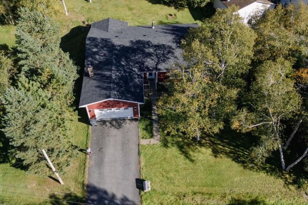 Aerial view of red siding house with attached garage and dark roof. - 13 Chippy's Lane, Appleton