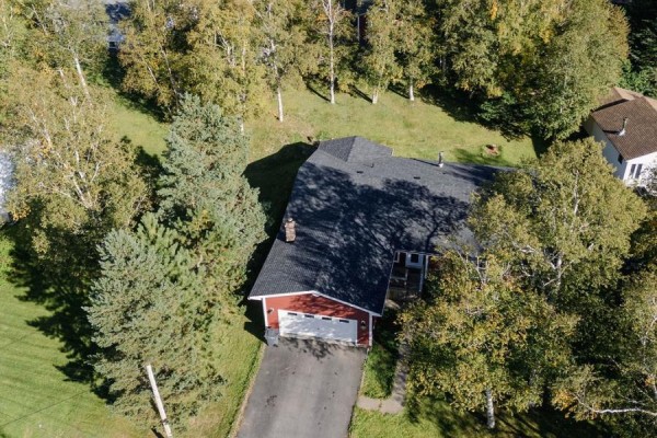 Aerial view of red siding house with attached garage surrounded by trees. - 13 Chippy's Lane, Appleton