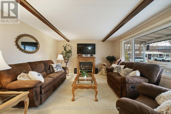 Narrow kitchen with wooden cabinets, stainless steel appliances, and a door leading outside - 13 Cypress Point Crescent, South Huron