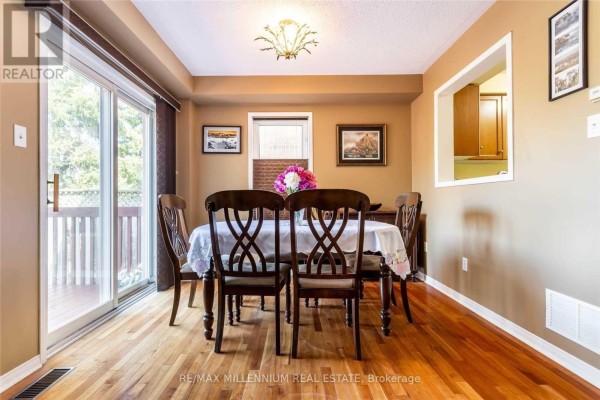 Dining room with a wooden table, chairs, and a sliding glass door. - 13 Dawson Crescent, Milton
