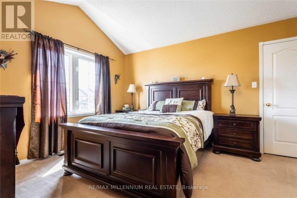 Bedroom with a large bed, vaulted ceiling, and dark wood furniture. - 13 Dawson Crescent, Milton