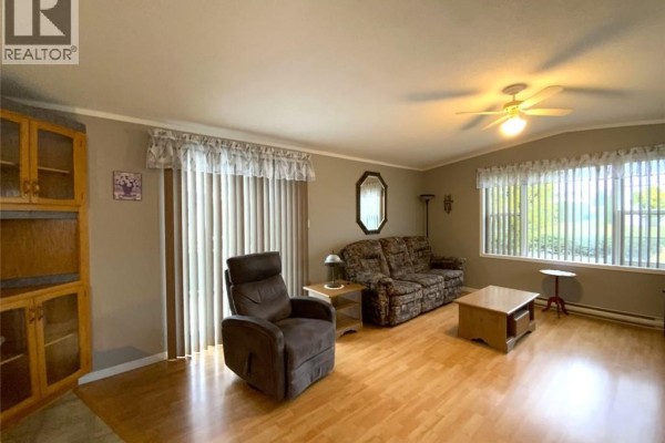 Living room with a sofa, recliner chair, coffee table, and large windows. - 13 Du Bouleau Street, Saint Jacques