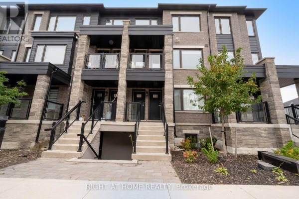Exterior of a modern townhouse with stone and dark siding, featuring multiple balconies and stairs. - 13 Magnolia Lane, Barrie