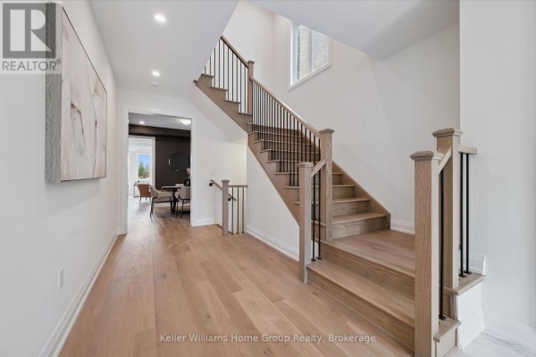 Interior entryway with white walls, hardwood floors, and a staircase with black railings. - 13 Mary Watson Street, North Dumfries