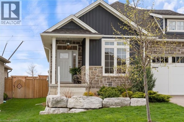 Close-up of the front entrance and garage of a modern house with stone and dark blue siding. - 13 Masters Lane, Paris
