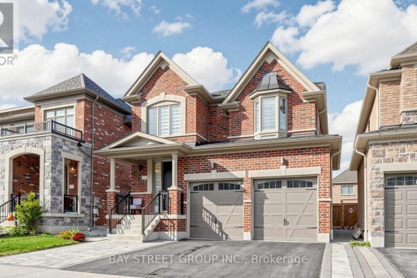Front view of a modern brick house with a covered porch and dual garage doors. - 13 Micklefield Avenue, Whitby