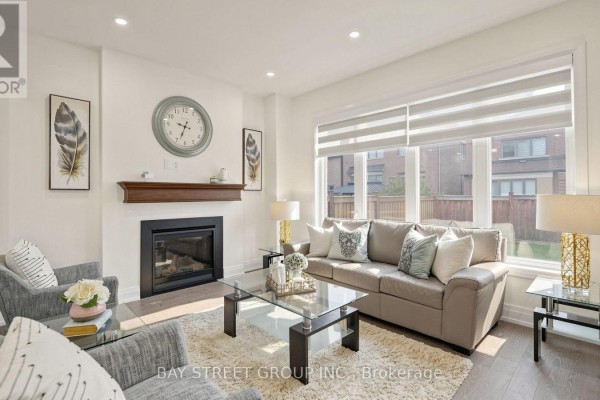 Living room with a fireplace, sofa, armchairs, glass coffee table, and a large window. - 13 Micklefield Avenue, Whitby
