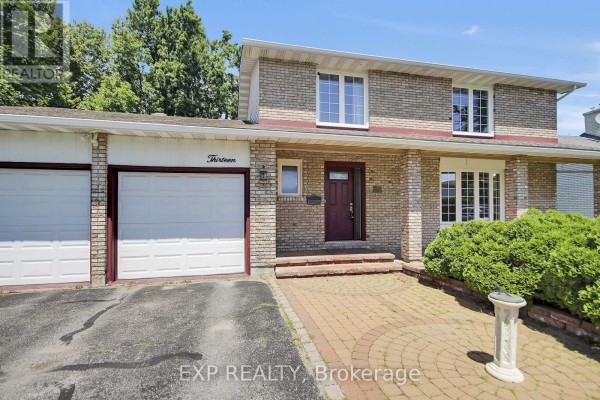 Close-up of the house entrance with a red door, adjacent window, and brick columns. - 13 Shanel Place, Ottawa