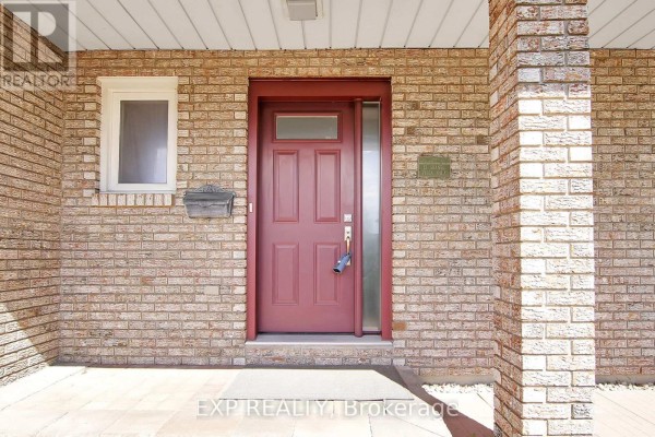 Detailed view of the front door with brickwork, sidelight, small window, and mailbox. - 13 Shanel Place, Ottawa