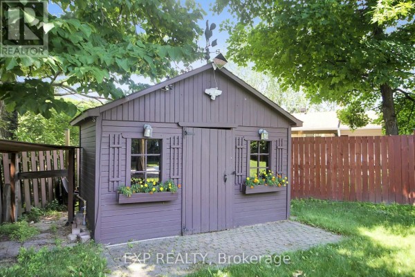 Brown shed with flower boxes, outdoor lights, and a weather vane - 13 Shanel Place Ottawa
