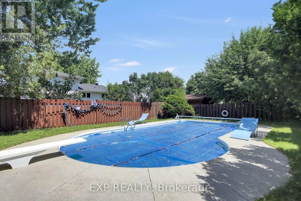 Covered swimming pool with diving board and lounge chairs - 13 Shanel Place Ottawa