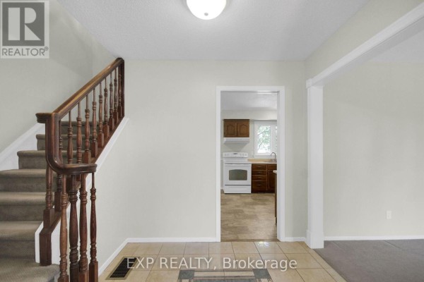 Hallway with staircase and view into kitchen - 13 Shanel Place Ottawa