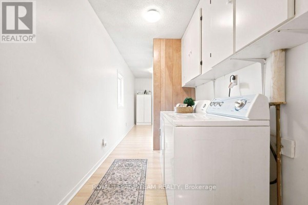 Laundry room with washer, dryer, and white cabinets - 13 Springfield Drive Whitewater Region