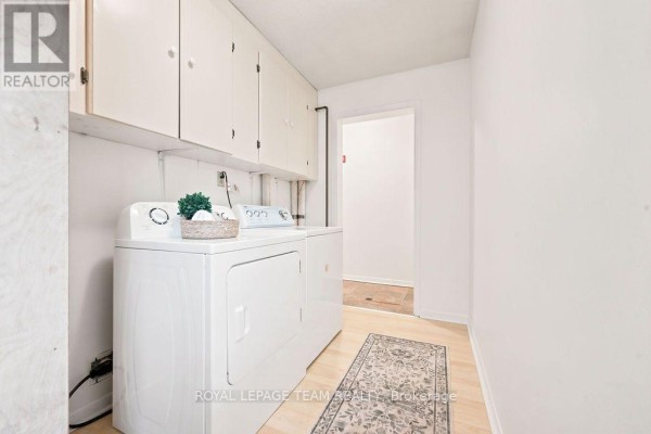 Laundry room with washing machine, dryer, and cabinets - 13 Springfield Drive Whitewater Region