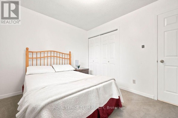 Bedroom with wooden headboard bed, closet, and nightstand - 13 Springfield Drive Whitewater Region