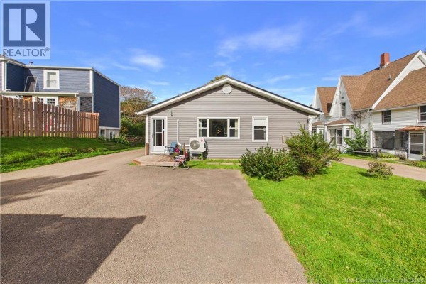 Rear exterior of a grey house with a back door and a small deck. - 13 Squire Street, Sackville