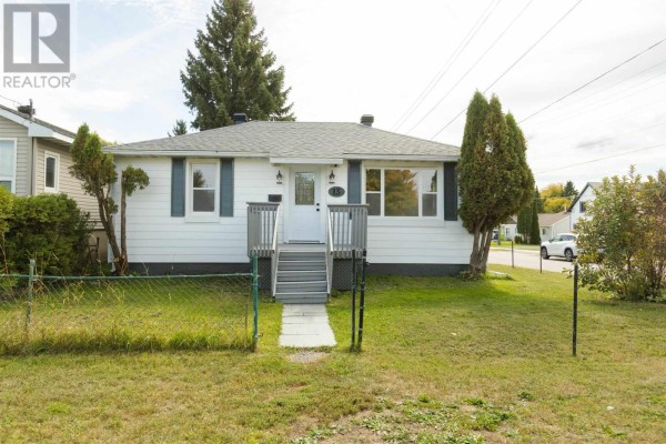A white house with dark blue shutters and a small porch with grey stairs. - 13 Stevens St, Sault Ste  Marie