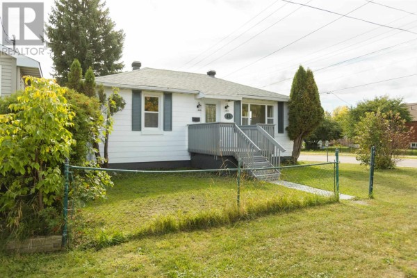 Side view of a white bungalow with a chain-link fence in the foreground. - 13 Stevens St, Sault Ste  Marie